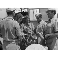Des soldats remplissent leur gourde devant un camion britannique de prise Chevrolet FAT (Field Artillery Tractor), le code postale FP 17967 est peint sur le véhicule.
