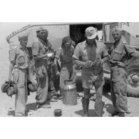 Des soldats remplissent leur gourde devant un camion britannique de prise Chevrolet FAT (Field Artillery Tractor), le code postale FP 17967 est peint sur le véhicule.