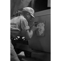 Application de l'insigne de l'Afrika-Korps à l'aide d'un pochoir.