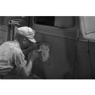 Application de l'insigne de l'Afrika-Korps à l'aide d'un pochoir.