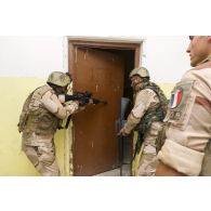 Des stagiaires irakiens investissent une pièce sous la supervision d'un instructeur français à Bagdad, en Irak.