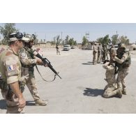 Des stagiaires irakiens neutralisent un élément dangereux sous la supervision d'un instructeur français à Bagdad, en Irak.