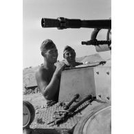 Un homme d'équipage casse des oeufs sur la plaque d'un casier extérieur du Panzer II et les fait cuire.