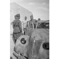 A l'intérieur du fort de Mechili, des officiers italiens, dont un officier général, posent puis parlent devant une voiture Fiat.