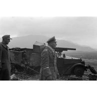 Le maréchal Rommel, accompagné d'officiers, passe près d'un semi-chenillé APC M3, équipé d'un canon antichar.