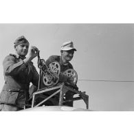 Deux soldats manoeuvrent un treuil installé sur un camion Dodge T215 d'origine américaine.
