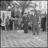 Cérémonie au monument aux morts d'Alger et ranimage de la flamme par Vincent Badie, ministre des Anciens combattants, en présence de Jacques Chevallier et Jacques Soustelle.