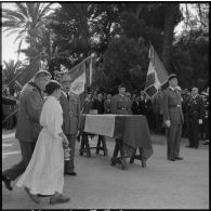 Un aumônier et un enfant de choeur rejoignant le cercueil du colonel Cerruti pour la bénédiction.