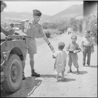Le sous-lieutenant Baril de la 4e compagnie du 1er bataillon du 9e régiment d'infanterie coloniale (RIC) donnant du pain aux enfants des environs de Rébeval.