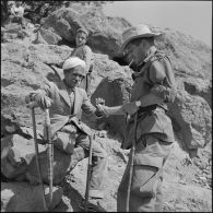 Le lieutenant Vangoethem de la 4e compagnie du 1er bataillon du 9e régiment d'infanterie coloniale (RIC) offrant une cigarette à un habitant des environs d'Afir.