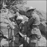 Le lieutenant Vangoethem de la 4e compagnie du 1er bataillon du 9e régiment d'infanterie coloniale (RIC) offrant une cigarette à un habitant des environs d'Afir.
