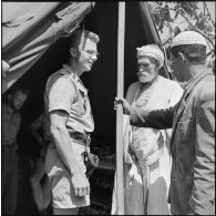 Le sous-lieutenant médecin Pierre Chaon de la 4e compagnie du 1er bataillon du 9e régiment d'infanterie coloniale (RIC) en conversation avec des malades.