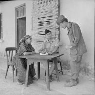 Le soldat Rosana et le lieutenant Faur-Perdigou de la 4e compagnie du 1er bataillon du 9e régiment d'infanterie coloniale (RIC) en entretien avec une jeune kabyle.