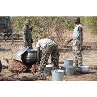 Des soldats maliens préparent l'ordinaire sous le regard d'un instructeur polonais sur le camp de Koulikoro, au Mali.