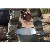 Un soldat malien dispose la viande pour la préparation de l'ordinaire en bivouac sur le camp de Koulikoro, au Mali.