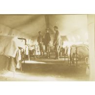 [Trois personnels médicaux au milieu des malades, s.d.]