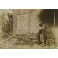 [Soldat posant devant des bas-reliefs signé "A Charnay" dans les carrières du Chauffour, s.d.]