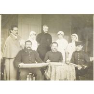 [Portrait de Jean Gélas entouré d'une équipe médicale aux côtés de trois soldats effectuant des travaux manuels, s.d.]
