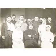 [Equipe médicale et malades posant à côté d'un adjudant, s.d.]