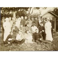 [Infirmières posant en extérieur avec un groupe de blessés, s.d.]