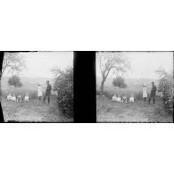 [Enfants assis dans l'herbe surveillés par une jeune fille et un soldat, s.d.]