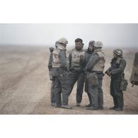 L'équipe de l'ECPA (Etablissement cinématographique et photographique des armées),composée du capitaine chef d'équipe, du brigadier caméraman et de l'adjudant photographe, discute au bord d'une piste.