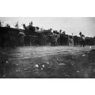 [Soldats en attente à côté de cellules à pièces d'artillerie, s.d.]