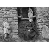 [Une femme âgée et un enfant posent devant un muret, s.d.]