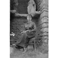 [Portrait d'une femme assise devant une niche sculptée, s.d.]