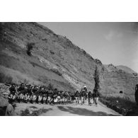 [Défilé d'un régiment de chasseurs alpins sur une route de montagne].
