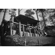 [Trois hommes devant une cabane en hauteur, s.d.]
