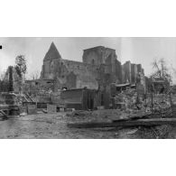 [Soldat posant dans un village en ruines, s.d.]