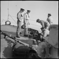 Déroulement de l'ancre par des matelots surveillée par un aspirant de marine sur l'escorteur Hova lors de la manoeuvre de mouillage.