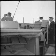 Un élément de l'équipage, un enseigne de vaisseau de 1re classe et un capitaine de frégate en mission de surveillance sur la passerelle de l'escorteur Hova.