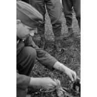 Un sous-officier (Unteroffizier), fauconnier de la Luftwaffe. nourrit un faucon apprivoisé.