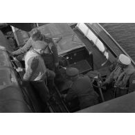 Des aviateurs allemands, dont un Oberstleutnant et des officiers de la Heer, discutent dans une vedette, à côté d'un hydravion B&V-138 du See-Aufklaerungsgruppe-125.