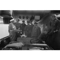 Des aviateurs allemands, dont un Oberstleutnant et des officiers de la Heer, discutent dans une vedette, à côté d'un hydravion B&V-138 du See-Aufklaerungsgruppe-125.