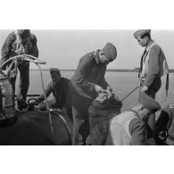 Amarrage d'un B&V-138 et déchargement de sacs par des aviateurs allemands, sous le regard des pilotes.