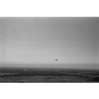 Un planeur monoplace de type DFS Habicht, du N.S.F.K. (Nationalistischen Flieger-Korps) en vol au dessus d'un paysage agricole allemand.
