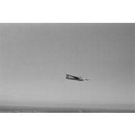 Un planeur monoplace de type DFS Habicht, du N.S.F.K. (Nationalistischen Flieger-Korps) en vol au dessus d'un paysage agricole allemand.