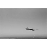 Un planeur monoplace de type DFS Habicht, du N.S.F.K. (Nationalistischen Flieger-Korps) en vol au dessus d'un paysage agricole allemand.