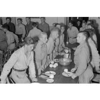 Jeunes membres du N.S.F.K. se levant de table lors d'un repas.