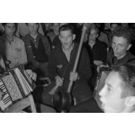 Des jeunes membres du N.S.F.K. chantent et jouent de la musique. Au milieu d'eux, une jeune recrue de la Luftwaffe.