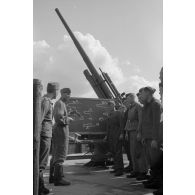 Un sous-officier de la Luftwaffe (Unteroffizier) de la FlaK apprend à des servants d'une pièce de 8,8 cm FlaK-18-L56.