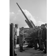 Un sous-officier de la Luftwaffe (Unteroffizier) de la FlaK apprend à des servants d'une pièce de 8,8 cm FlaK-18-L56.