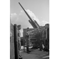 Un sous-officier de la Luftwaffe (Unteroffizier) de la FlaK apprend à des servants d'une pièce de 8,8 cm FlaK-18-L56.