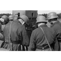 Des servants d'un télémètre de soutien, Kommandohilfsgeraet-35, au travail, sous la direction d'un Leutnant.