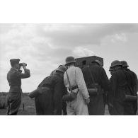 Des servants d'un télémètre de soutien, Kommandohilfsgeraet-35, au travail, sous la direction d'un Leutnant.