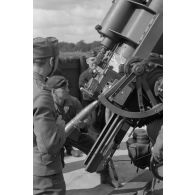 Un servant d'une pièce de 8,8 cm FlaK-18-L56 introduit un obus dans la culasse du canon.