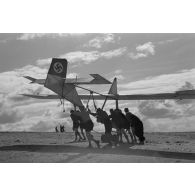 Des jeunes membres du Nationalsozialistischen Flieger-Korps (N.S.F.K.) acheminent un planeur léger sur son aire d'envol.